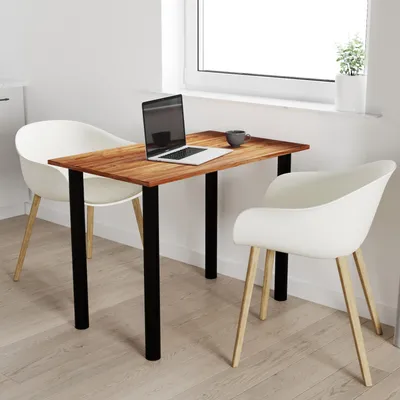 A small wooden table with black legs, a laptop, and a mug, placed next to a window with two white chairs.