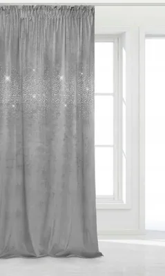 A gray velvet curtain with glitter accents hangs in front of a window.