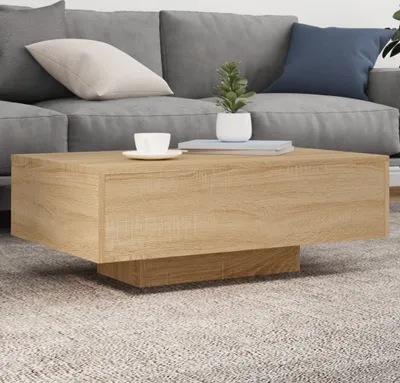 A coffee table in front of a sofa in a living room setting.