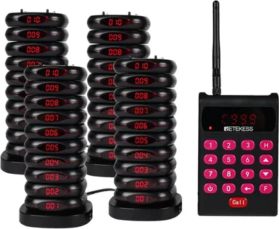 A set of restaurant pagers and a charging base with a remote.