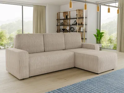 A beige corduroy sectional sofa is shown in a well-lit living room with a large window overlooking a natural landscape.