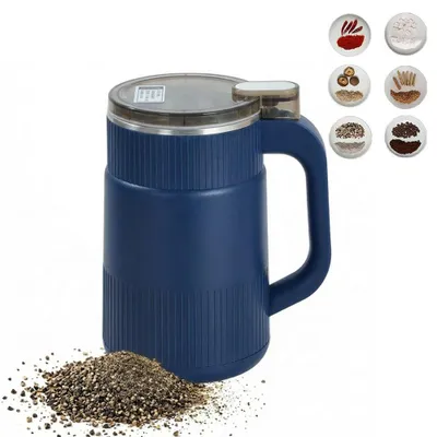 A blue electric grinder with a pile of ground material in front of it, and a set of small ingredient samples in the background.