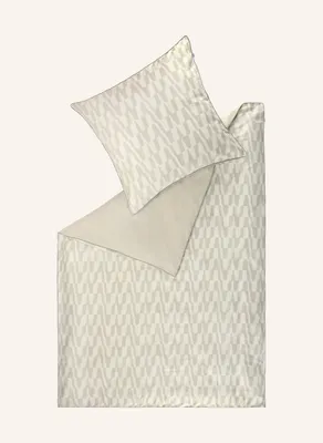 A duvet cover and pillowcase with a geometric pattern are laid out flat on a light beige background.