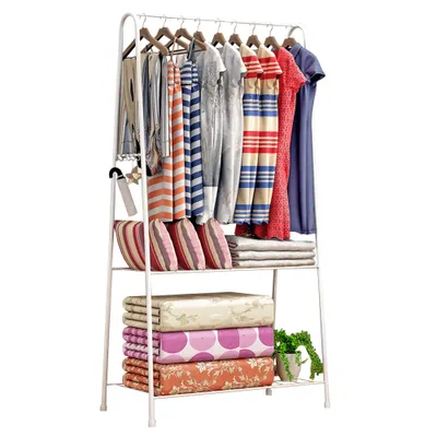 A white metal garment rack with clothes and folded bedding.