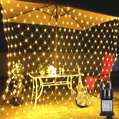 An outdoor patio scene at night, decorated with a net of warm white fairy lights.