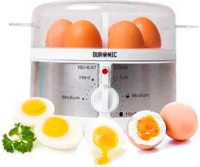An egg cooker with eggs inside and boiled eggs displayed in front.