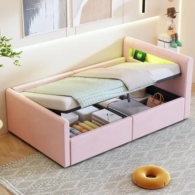 A pink upholstered bed with storage compartments open, revealing various items inside. The bed has integrated LED lighting.