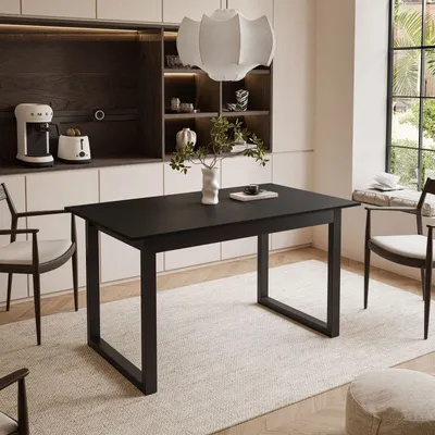 A dining room with a black table and chairs, set up for a meal.