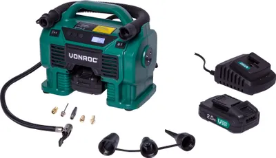 A green portable air compressor with accessories and two batteries on a white background.