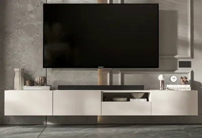 A modern TV cabinet with a television mounted above it, set against a textured wall.