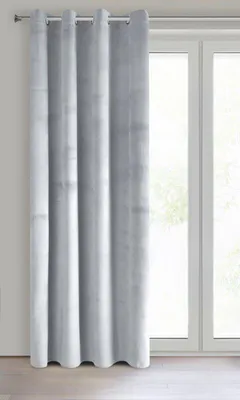 A light gray curtain with grommets hangs in front of a window.