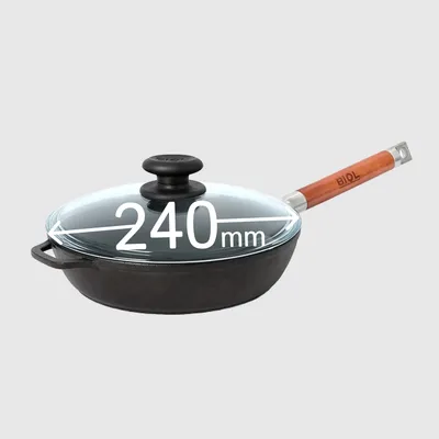 A cast iron frying pan with a glass lid and a wooden handle is shown against a plain background. Dimensions are indicated on the lid.