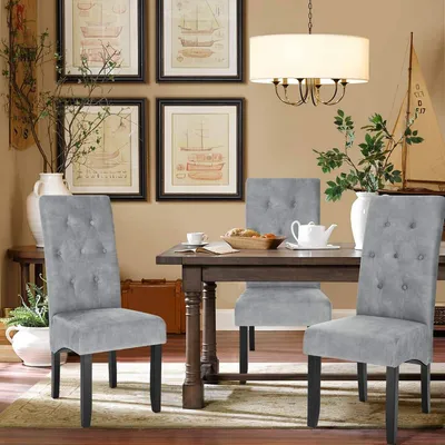A dining room set with four chairs around a table, with artwork on the wall.