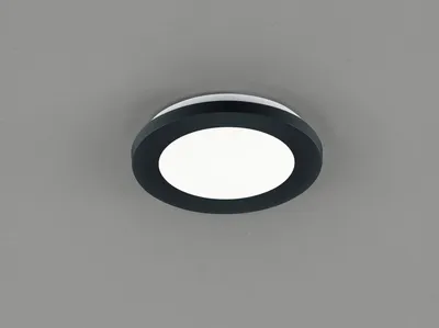 A close-up shot of a circular LED ceiling light with a black frame and a white light source, mounted on a light gray ceiling.