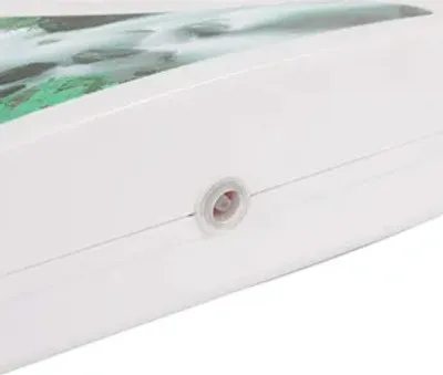 Close-up of a white electronic device with a small circular port on its side.