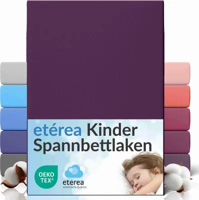 A flat lay image of a purple fitted sheet, with stacks of other colored sheets visible on the sides, and a sleeping child in the lower right corner.