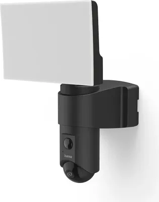 A black outdoor security camera with a white light attached, mounted on a white wall.