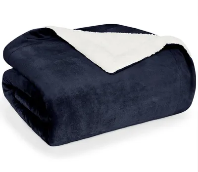 A folded dark blue sherpa blanket with a white sherpa lining is shown against a white background.