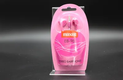 A pink retail package of Maxell EB-98 stereo earphones is displayed on a clear stand against a black background.