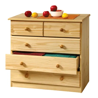 A light-colored wooden chest of drawers with five drawers, two on top and three below. The top surface has a small bowl with red apples and two yellow fruits. One of the lower drawers is open, showing folded red and green fabric inside. Apples and lemons a