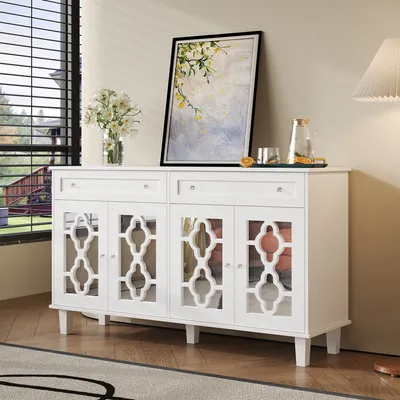 A white sideboard with decorative doors and drawers is placed in a room with a window and a painting on the wall.