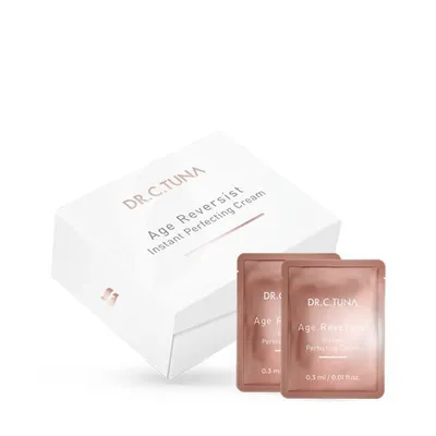 A white box with the product name and two small sample packets of cream.