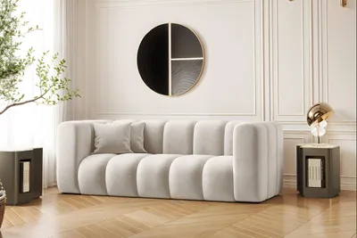 A modern living room with a light gray sofa, side tables, and wall art.