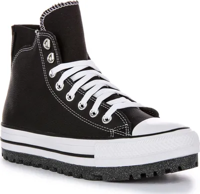 A studio shot of a black high-top sneaker with a thick white platform sole and a lug sole.