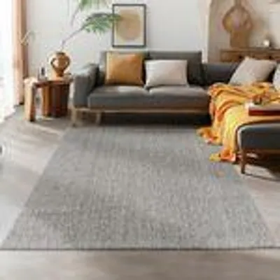 A living room scene with a sofa, rug, and side table.