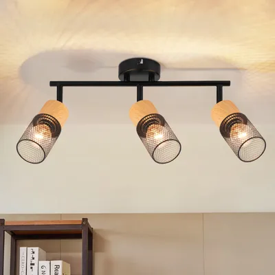 A three-light ceiling fixture with adjustable spotlights, featuring black metal and wood accents, mounted on a white ceiling.