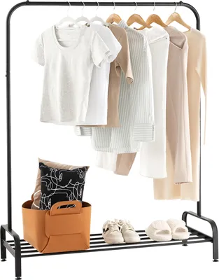 A clothing rack with several garments hanging on it, and a basket with pillows and shoes on the shelf below.