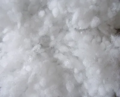 A close-up, abstract view of white, fluffy material, resembling artificial snow.