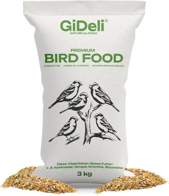 A bag of bird food with illustrations of birds on it, shown with some of the food spilled at the bottom.