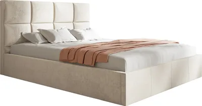 A beige upholstered bed with a tufted headboard and a peach-colored throw blanket.