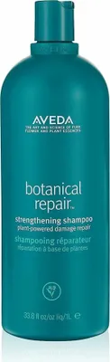 A teal colored bottle of Aveda Botanical Repair Strengthening Shampoo against a white background.