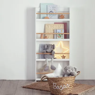A white bookshelf with wooden shelves filled with books, toys, and a decorative star light.