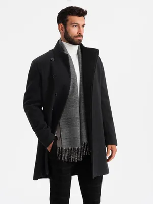 A man is modeling a black coat with a white turtleneck and a gray scarf.