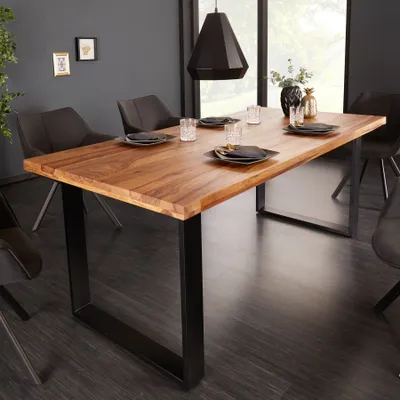 A dining room scene with a wooden table and chairs.