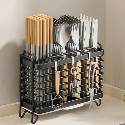 A kitchen utensil holder filled with cutlery and chopsticks, placed on a countertop.