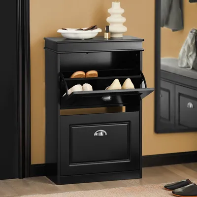 A black shoe cabinet with two flip-down doors and a drawer, placed in a hallway or entryway.