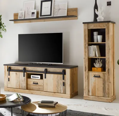 A living room setting featuring a TV stand, a tall cabinet, and a wall shelf, all in a rustic wood finish.
