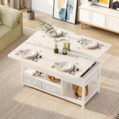 A white coffee table that can be extended into a dining table, set with plates and cutlery, in a living room setting.
