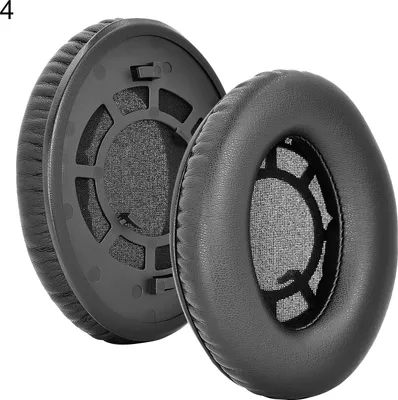 Two black ear pads for headphones are shown against a white background. One ear pad is shown from the side, revealing its internal structure, while the other is shown from the front.