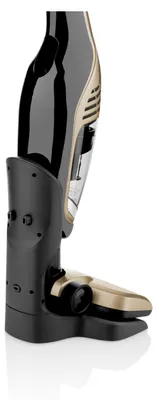 A close-up side view of a cordless vacuum cleaner docked in its charging base.