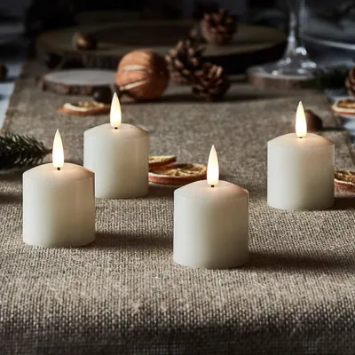 Produktbild von Lights4fun TruGlow® 4er-Set Teelichter-Kerzen | warmweiße LEDs | mit Timerfunktion | Batteriebetrieben | Weihnachten Advent Christfest | Echtwachs flackernde Flamme Klein | Höhe 5,5 cm | Cremefarben