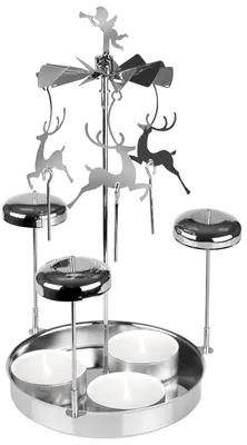 A silver metal Christmas-themed rotating candle holder with reindeer figures and an angel on top.