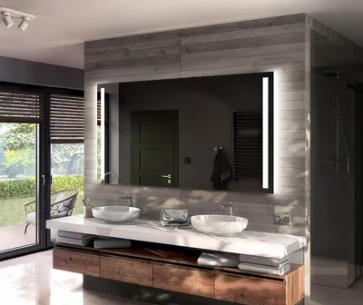 A modern bathroom vanity with a large LED mirror, two sinks, and wooden cabinetry.