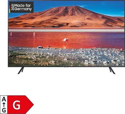 A Samsung television displaying a landscape image, with its stand visible.