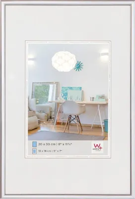 A white picture frame with a matting, displaying a lifestyle image of a home office or living space.