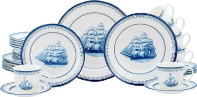A set of dinnerware with a nautical theme, featuring blue sailing ships on white plates and cups.